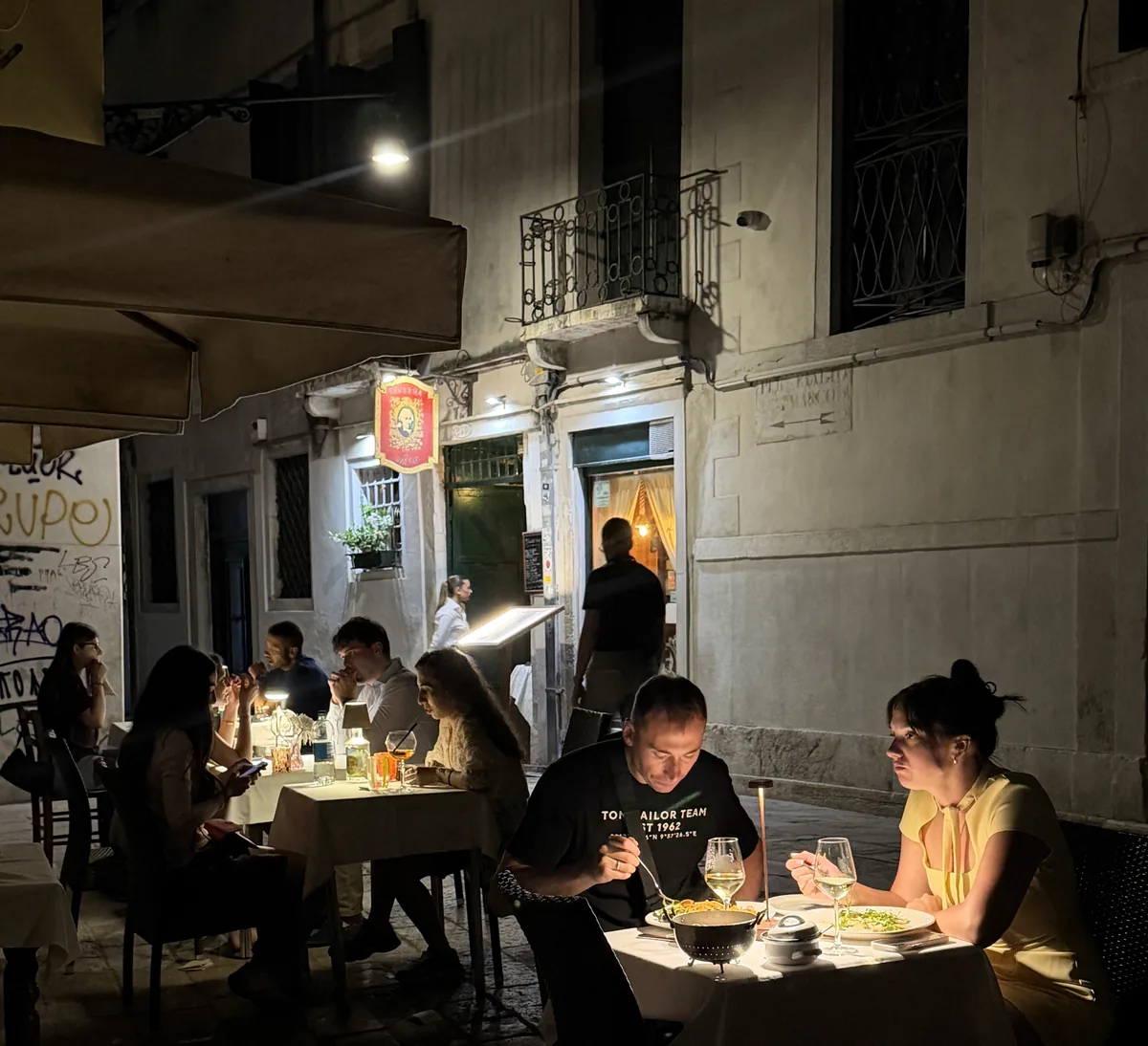 Coppie a cena la sera ai tavoli all'aperto della taverna