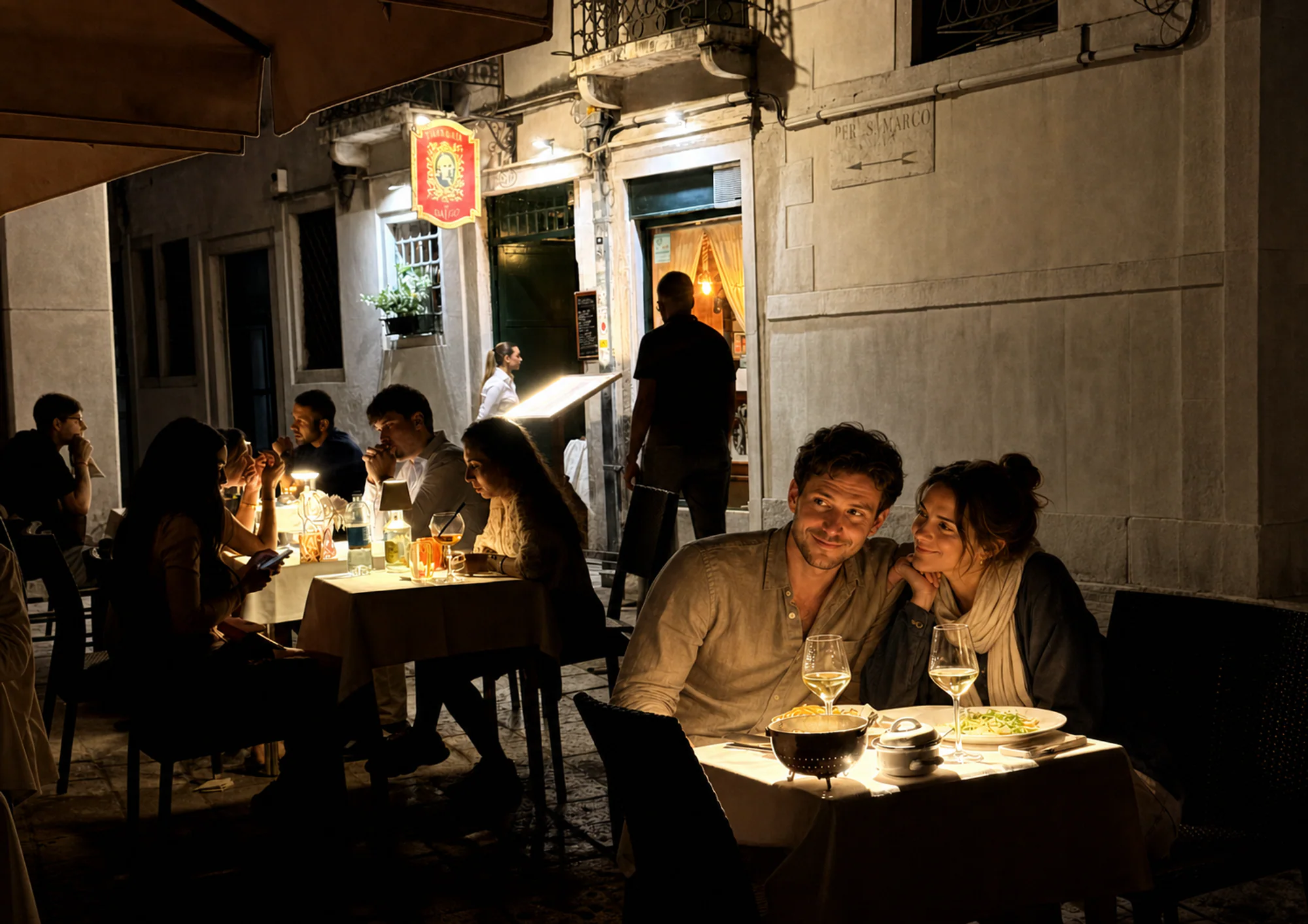 Couples dining by candlelight under Taverna da Baffo's red lantern sign, in Campiello Sant'Agostin at night