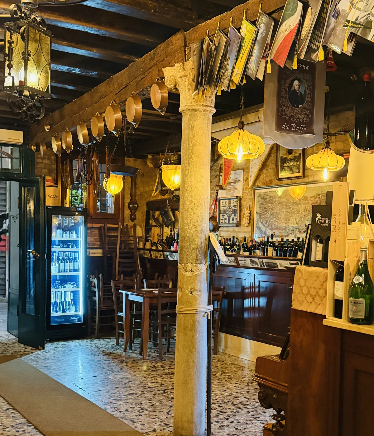 La sala con le colonne di legno e le lanterne veneziane accese